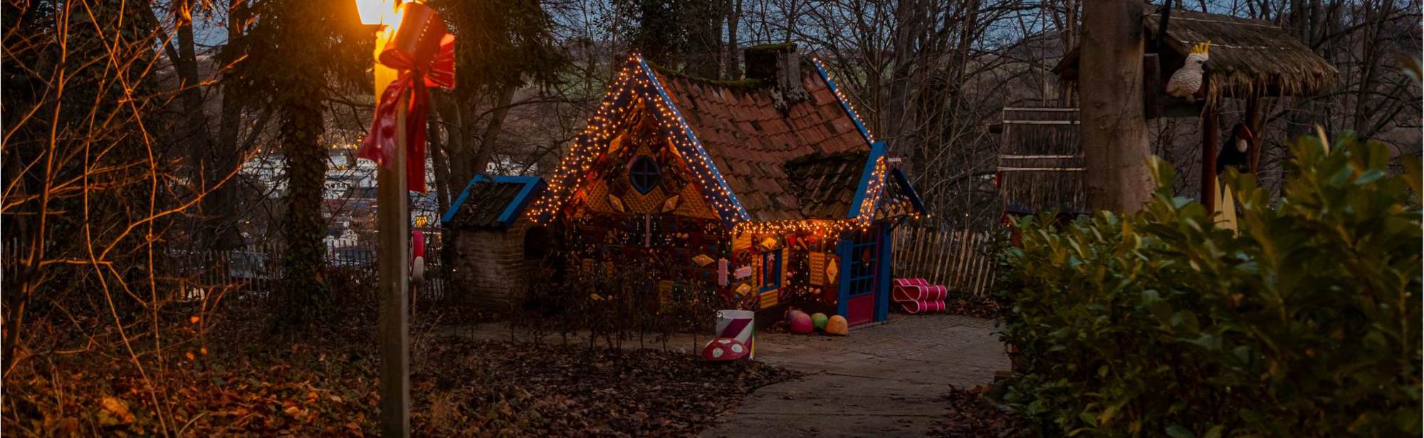 Kerstversiering aan huisje sprookjesbos in de avond
